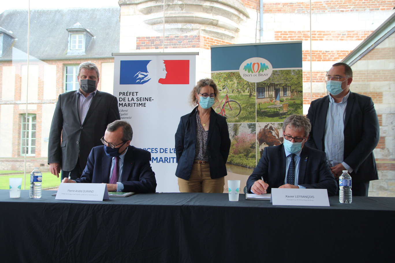 De g. à dr. : Debouts, les présidents d’intercommunalités Eric Picard (Quatre Rivières), Armelle Biloquet (Londinières) et Nicolas Bertrand (Bray-Eawy), assistent à la signature du CRTE par Pierre-André Durant et Xavier Lefrançois. (© Aletheia Press / Benoit Delabre)