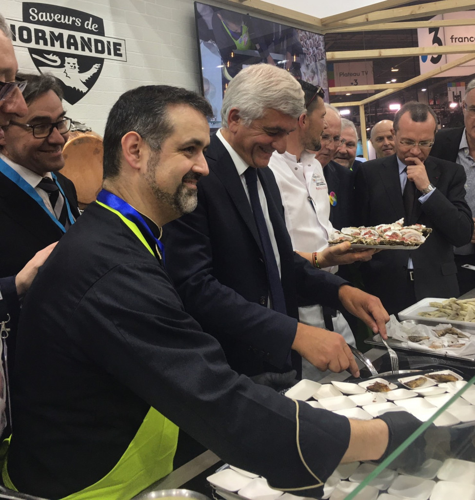 Crédit photo : AgGu /Aletheia Press ,« Normandie 1 Sur le stand du Show’Dron Hervé Morin s’initie à une recette du chef Paulo Ferreira. »